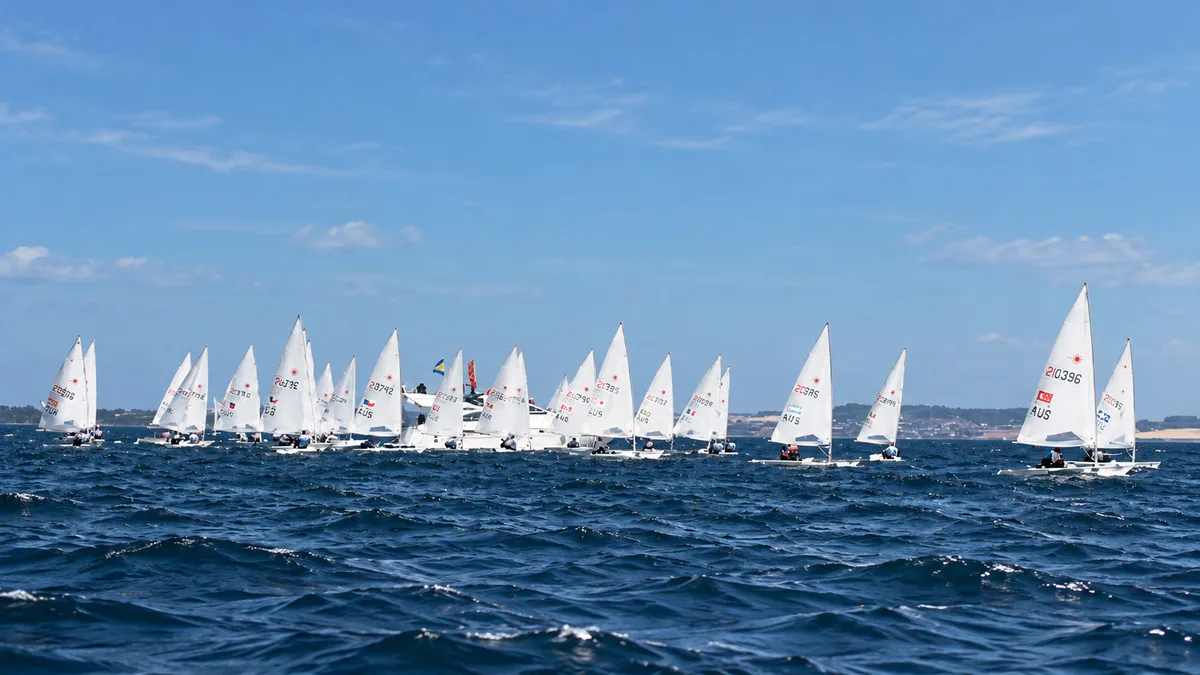 A fleet of dinghies racing across the water