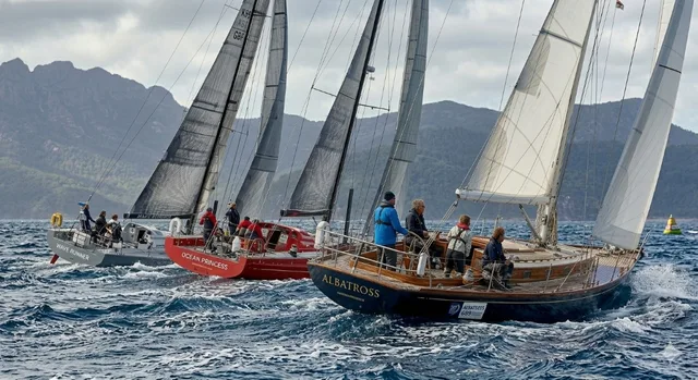 Sailing crews racing together on the water
